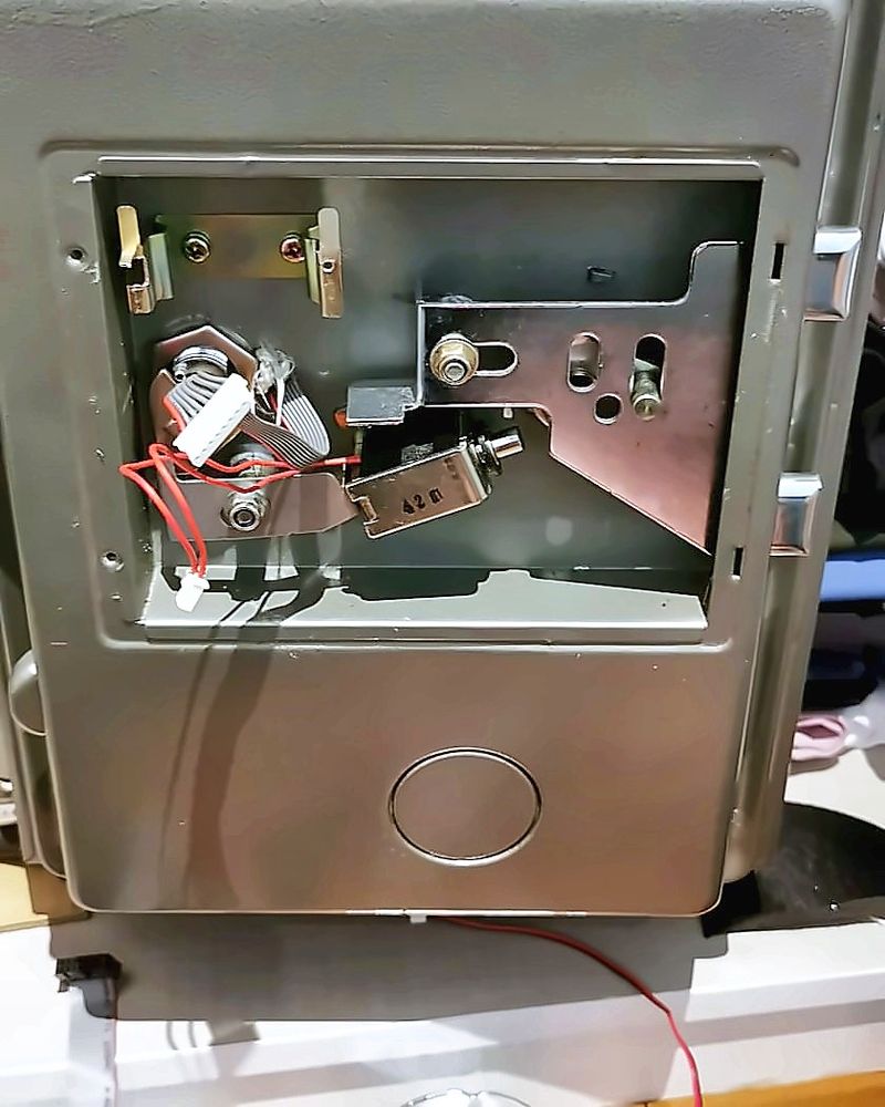 Safe door with the lock panel removed, showing the bolt mechanism and wiring