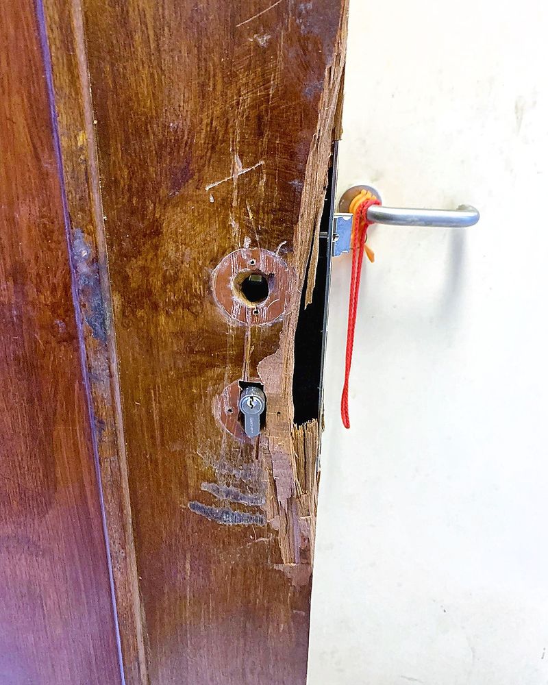 Damaged wooden main door with the old lock removed and splintered edge