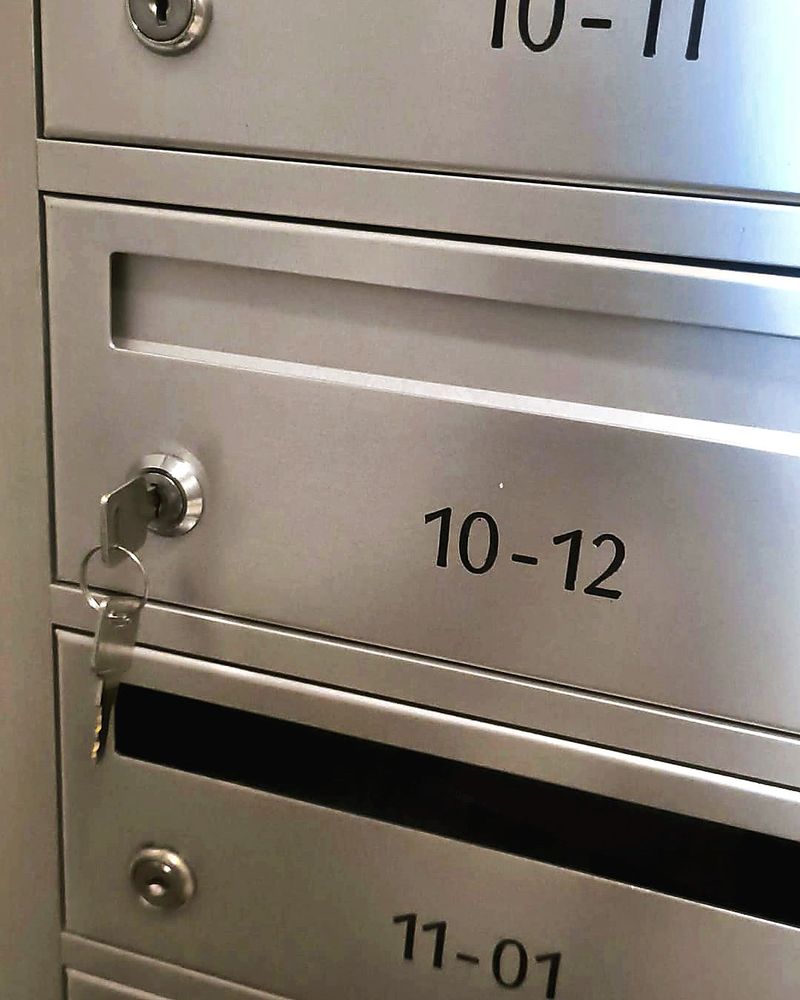 Key in a new lock on a stainless steel letterbox in Singapore