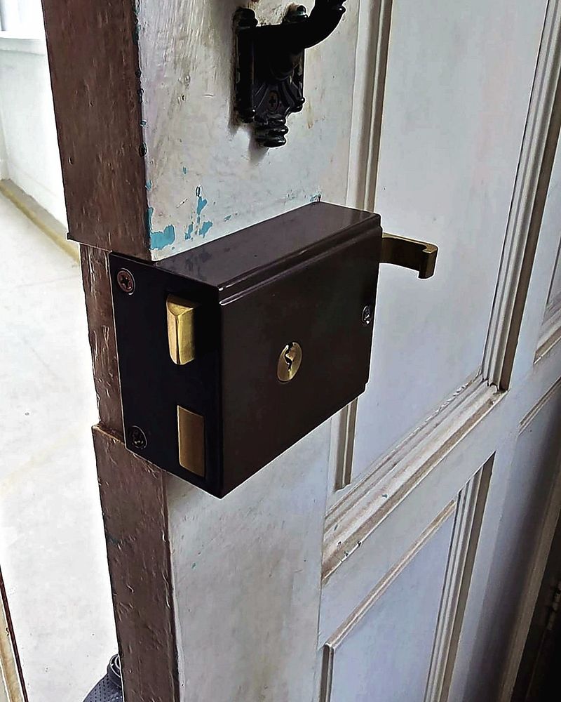 New rim lock with brass latch fitted to a white panelled door